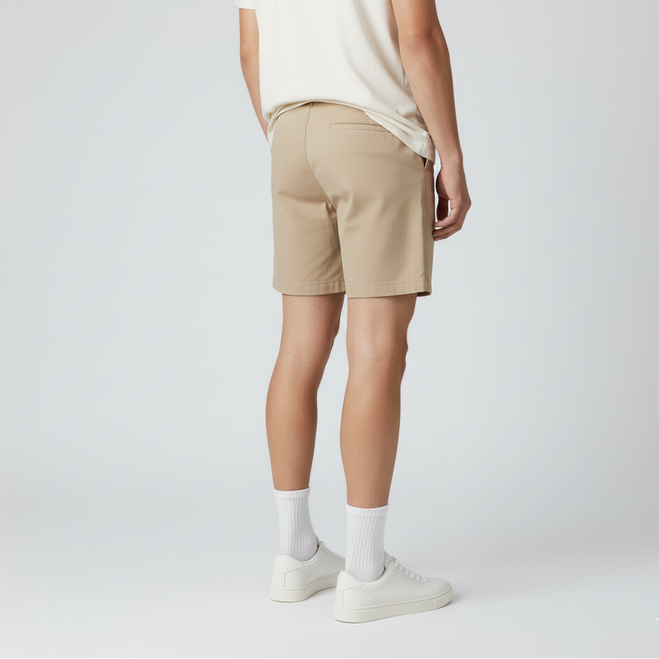 Person wearing beige shorts on a white background