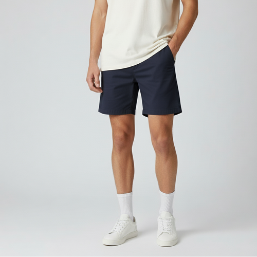 Person wearing navy shorts and a white t-shirt on a plain background